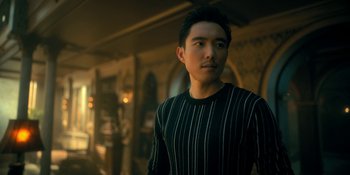 Movie still from “The Umbrella Academy” (2019), created by Steve Blackman – A man in a black and white striped shirt; Medium shot, Low angle