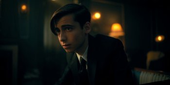 Movie still from “The Umbrella Academy” (2019), created by Steve Blackman – A man in a suit and tie looking at the camera; Close Up shot, Over the shoulder angle