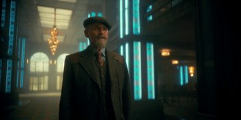 Movie still from “The Umbrella Academy” (2019), created by Steve Blackman – An older man in a suit and hat standing in a room; Medium shot, Low angle