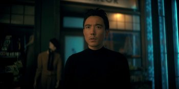 Movie still from “The Umbrella Academy” (2019), created by Steve Blackman – A man standing in front of a building at night; Close Up shot, Low angle