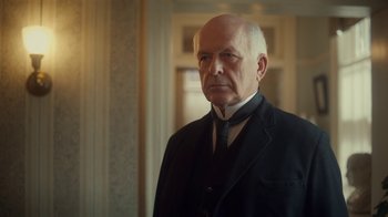 Movie still from “Anne with an E” (2017), created by Moira Walley-Beckett – An older man wearing a suit and tie; Close Up shot, Low angle