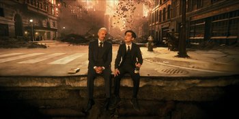 Movie still from “The Umbrella Academy” (2019), created by Steve Blackman – Two men in suits sitting next to each other on a wall; Wide shot, High angle