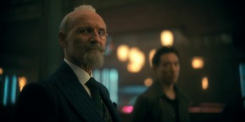 Movie still from “The Umbrella Academy” (2019), created by Steve Blackman – A man with a long beard and a man with a long mustache; Close Up shot, Over the shoulder angle