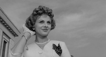 Movie still from “The Visit” (1964), directed by Bernhard Wicki – An old photo of an older woman in a white suit; Close Up shot, Low angle