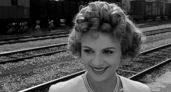 Movie still from “The Visit” (1964), directed by Bernhard Wicki – A black and white photo of a woman smiling; Close Up shot, Low angle