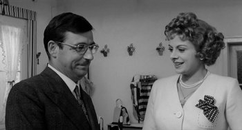 Movie still from “The Visit” (1964), directed by Bernhard Wicki – An older man and a younger woman standing next to each other; Close Up shot, Over the shoulder angle