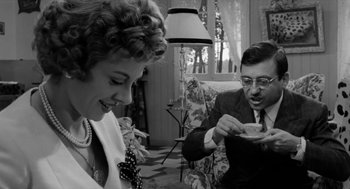 Movie still from “The Visit” (1964), directed by Bernhard Wicki – An old photo of a man and a woman drinking tea; Medium shot, Over the shoulder angle