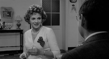 Movie still from “The Visit” (1964), directed by Bernhard Wicki – An older woman sitting at a table with a man; Close Up shot, Over the shoulder angle