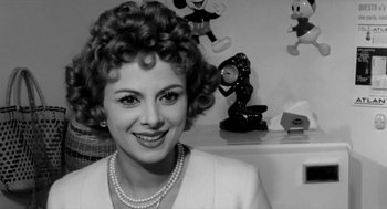 Movie still from “The Visit” (1964), directed by Bernhard Wicki – An old black and white photo of a woman in a room; Close Up shot, Low angle
