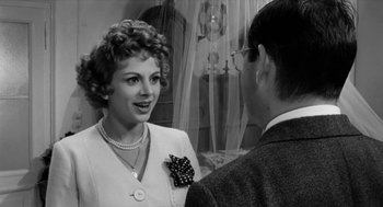 Movie still from “The Visit” (1964), directed by Bernhard Wicki – An old photo of a woman talking to a man; Close Up shot, Over the shoulder angle