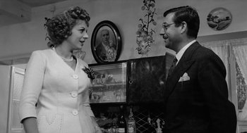 Movie still from “The Visit” (1964), directed by Bernhard Wicki – An old photo of a man and a woman looking at each other; Medium shot, Over the shoulder angle