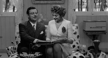 Movie still from “The Visit” (1964), directed by Bernhard Wicki – An older man sitting next to an older woman; Medium shot, High angle