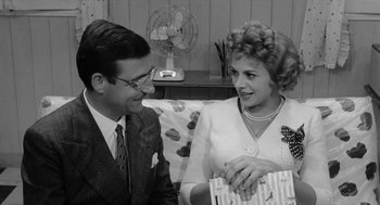 Movie still from “The Visit” (1964), directed by Bernhard Wicki – A man and a woman sitting next to each other; Medium shot, Over the shoulder angle