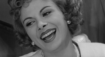 Movie still from “The Visit” (1964), directed by Bernhard Wicki – An old photo of a woman smiling for the camera; Close Up shot, Low angle