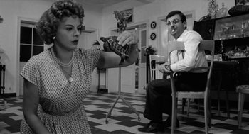 Movie still from “The Visit” (1964), directed by Bernhard Wicki – A man and a woman are holding a snake; Medium shot, Over the shoulder angle