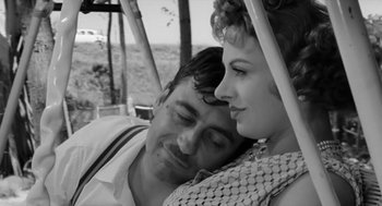 Movie still from “The Visit” (1964), directed by Bernhard Wicki – A man and a woman sitting close together on top of a bus; Close Up shot, High angle