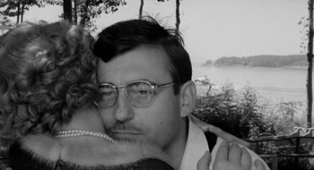 Movie still from “The Visit” (1964), directed by Bernhard Wicki – A black and white photo of a man and a woman hugging; Close Up shot, Over the shoulder angle