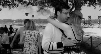 Movie still from “The Visit” (1964), directed by Bernhard Wicki – A man and a woman hugging in front of a tree; Medium shot, Over the shoulder angle