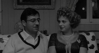 Movie still from “The Visit” (1964), directed by Bernhard Wicki – A man and a woman standing next to each other; Close Up shot, Over the shoulder angle