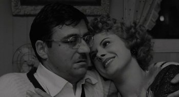 Movie still from “The Visit” (1964), directed by Bernhard Wicki – An older man and a younger woman posing for a picture; Close Up shot, Low angle