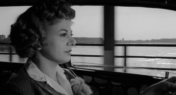 Movie still from “The Visit” (1964), directed by Bernhard Wicki – A black and white photo of a woman looking out of a window; Close Up shot, Low angle