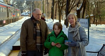 Movie still from “The Visit” (2015), directed by M. Night Shyamalan – An older man and a young boy and an older woman standing on a sidewalk; Medium shot, Over the shoulder angle