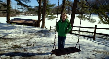 Movie still from “The Visit” (2015), directed by M. Night Shyamalan – A woman in a green jacket is on a swing; Wide shot, High angle