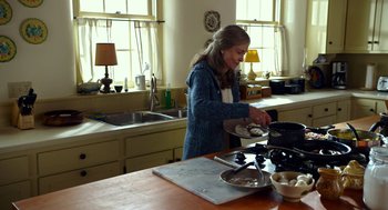 Movie still from “The Visit” (2015), directed by M. Night Shyamalan – A woman in a kitchen preparing food on a stove; Medium shot, Over the shoulder angle