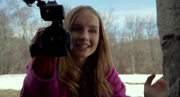 Movie still from “The Visit” (2015), directed by M. Night Shyamalan – A woman holding up a video camera to take a picture; Close Up shot, Over the shoulder angle