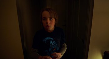 Movie still from “The Visit” (2015), directed by M. Night Shyamalan – A young boy is standing in the dark; Close Up shot, Over the shoulder angle