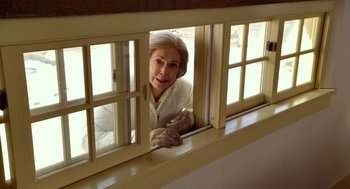 Movie still from “The Visit” (2015), directed by M. Night Shyamalan – An older woman looking out of a window; Medium shot, Low angle