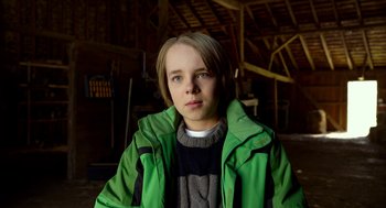 Movie still from “The Visit” (2015), directed by M. Night Shyamalan – A young man in a green jacket in a barn; Close Up shot, Low angle