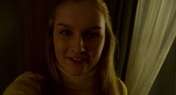 Movie still from “The Visit” (2015), directed by M. Night Shyamalan – A young woman with long blonde hair wearing a yellow sweater; Close Up shot, Low angle