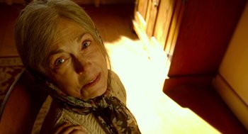 Movie still from “The Visit” (2015), directed by M. Night Shyamalan – An older woman wearing a sweater and a scarf; Close Up shot, Low angle