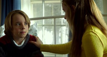 Movie still from “The Visit” (2015), directed by M. Night Shyamalan – A woman is helping a boy with a sweater; Close Up shot, Over the shoulder angle