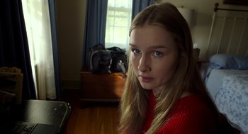 Movie still from “The Visit” (2015), directed by M. Night Shyamalan – A young woman with long blonde hair wearing a red sweater; Close Up shot, High angle