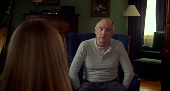 Movie still from “The Visit” (2015), directed by M. Night Shyamalan – An older man sitting in a chair talking to a young woman; Medium shot, Over the shoulder angle