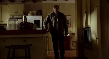 Movie still from “The Visit” (2015), directed by M. Night Shyamalan – A man standing in a kitchen in front of a counter; Medium shot, Low angle