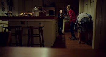 Movie still from “The Visit” (2015), directed by M. Night Shyamalan – Two women and a child in a kitchen; Wide shot, Over the shoulder angle