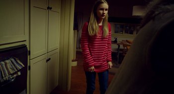 Movie still from “The Visit” (2015), directed by M. Night Shyamalan – A young girl standing in front of a mirror in a room; Medium shot, Over the shoulder angle