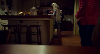 Movie still from “The Visit” (2015), directed by M. Night Shyamalan – Two people standing in a kitchen looking at something on the counter; Wide shot, Over the shoulder angle