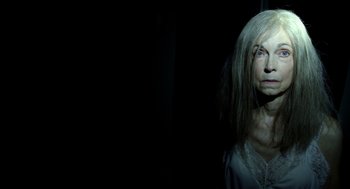 Movie still from “The Visit” (2015), directed by M. Night Shyamalan – A woman with long white hair is standing in the dark; Close Up shot, Low angle