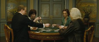 Movie still from “The Walker” (2007), directed by Paul Schrader – A group of people sitting around a table playing cards; Medium shot, High angle