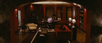 Movie still from “The Walker” (2007), directed by Paul Schrader – A man sitting at a table in a living room; Extreme Wide shot, High angle
