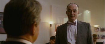 Movie still from “The Walker” (2007), directed by Paul Schrader – A man in a suit and bow tie standing in front of another man in a suit and bow tie; Close Up shot, Over the shoulder angle