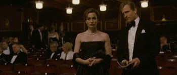 Movie still from “The Walker” (2007), directed by Paul Schrader – A woman in a black dress standing in front of a crowd; Medium shot, Low angle