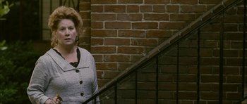 Movie still from “The Walker” (2007), directed by Paul Schrader – A woman standing on the stairs of a building; Medium shot, High angle