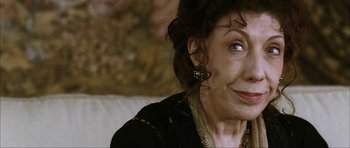 Movie still from “The Walker” (2007), directed by Paul Schrader – An older woman wearing a black jacket and earrings; Close Up shot, High angle
