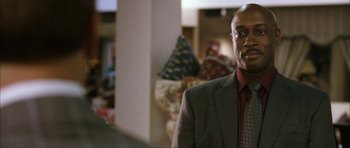 Movie still from “The Walker” (2007), directed by Paul Schrader – A man in a suit and tie standing in a room; Close Up shot, Over the shoulder angle