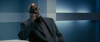Movie still from “The Walker” (2007), directed by Paul Schrader – A man in a suit and tie sitting in front of a wall; Close Up shot, Low angle